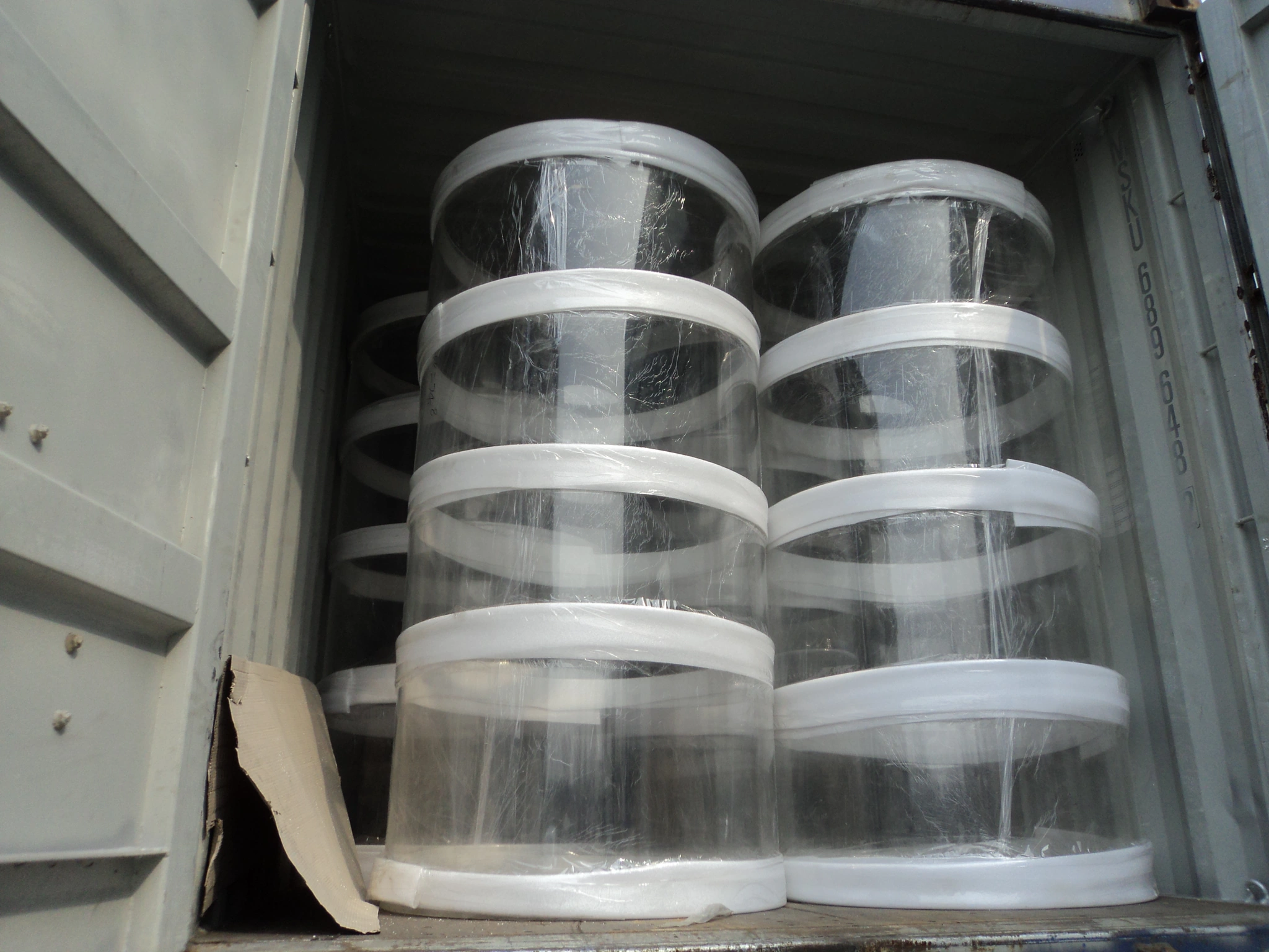 Transparent acrylic cylinders secured upright inside a shipping container for export