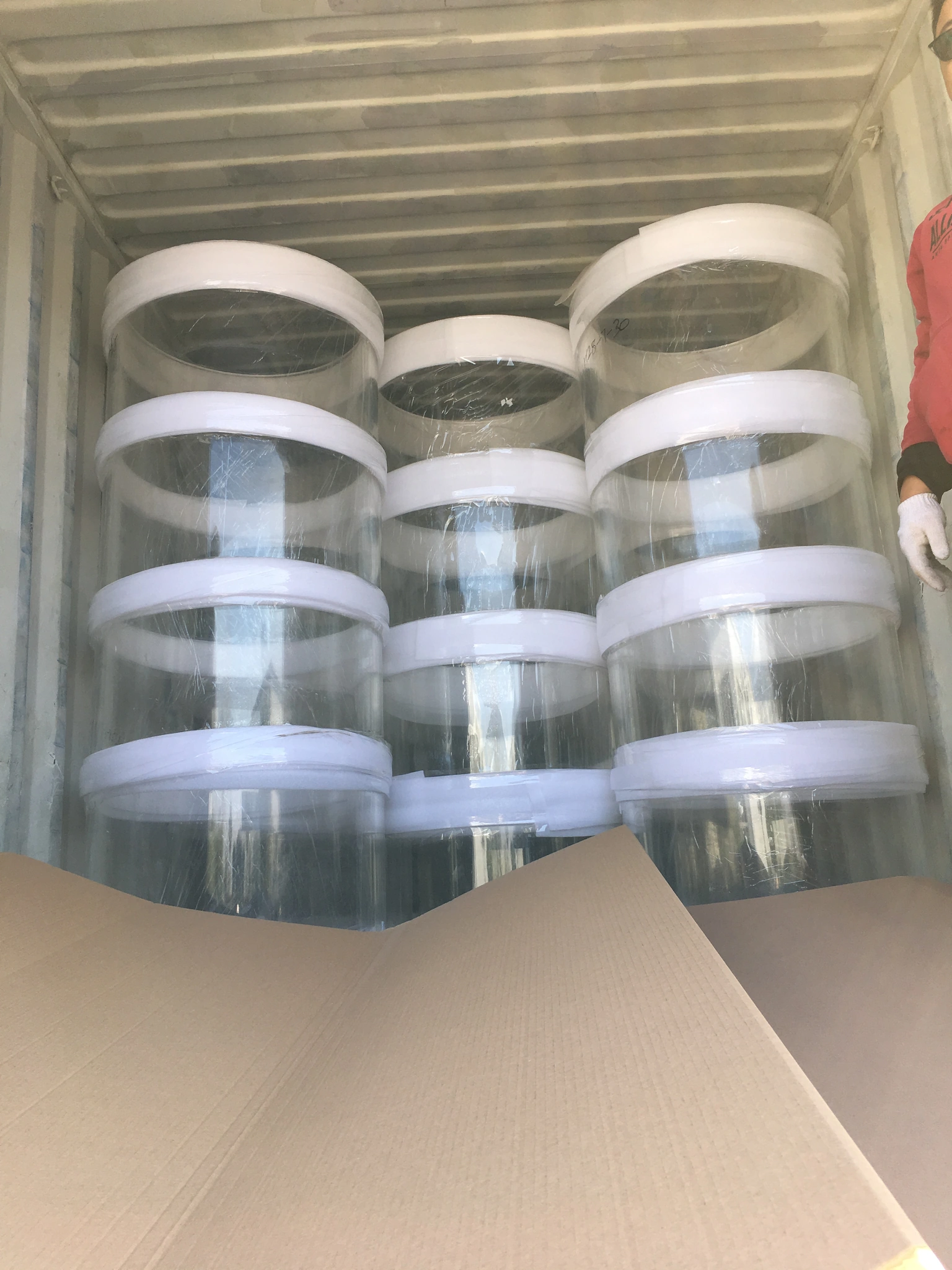 Multiple transparent acrylic cylinders prepared upright for export packaging